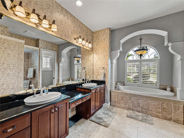 bathroom featuring vanity, tile patterned flooring, and tiled bath