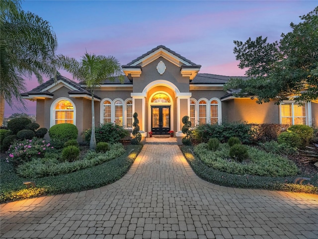 mediterranean / spanish-style house with french doors and stucco siding