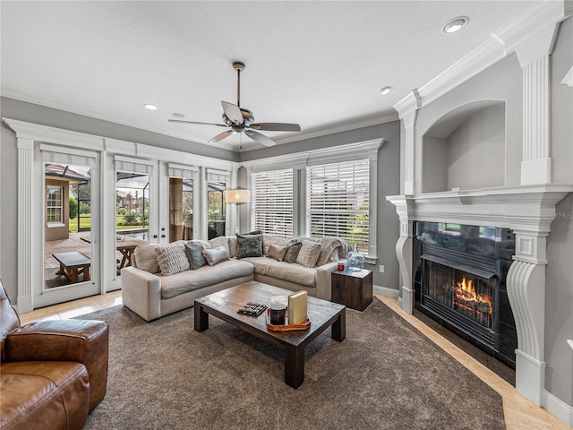 living area with ceiling fan, a tile fireplace, recessed lighting, baseboards, and crown molding