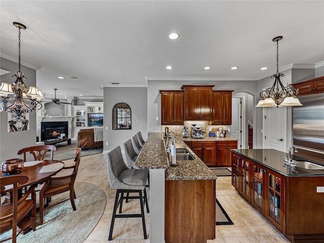 kitchen with a breakfast bar, a sink, decorative backsplash, and an inviting chandelier