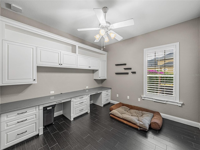 office area featuring a ceiling fan, wood tiled floor, built in study area, and baseboards