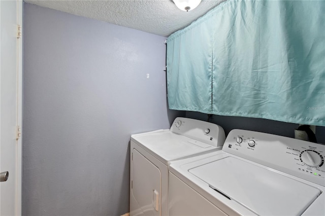 washroom with a textured ceiling and independent washer and dryer