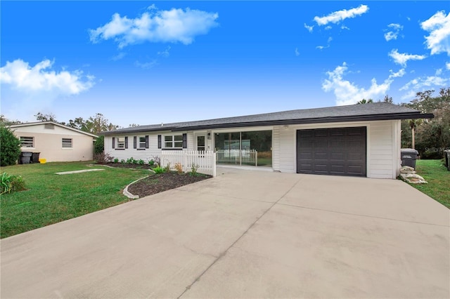 single story home featuring a front yard, a porch, and a garage