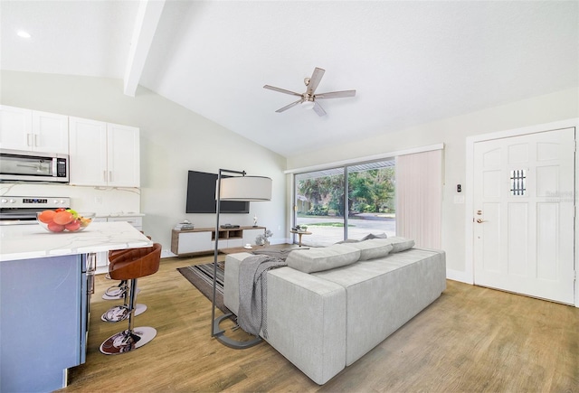 living room featuring lofted ceiling with beams, ceiling fan, and light hardwood / wood-style floors