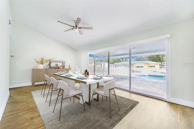 dining area with ceiling fan, vaulted ceiling, and hardwood / wood-style flooring