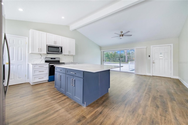 kitchen with appliances with stainless steel finishes, ceiling fan, dark wood-type flooring, white cabinets, and vaulted ceiling with beams