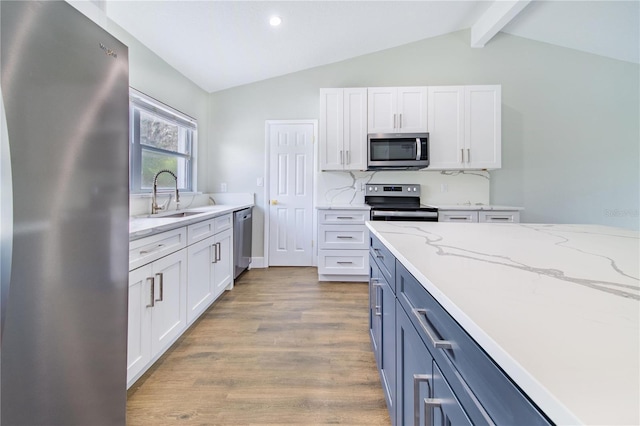 kitchen featuring white cabinets, appliances with stainless steel finishes, backsplash, and sink