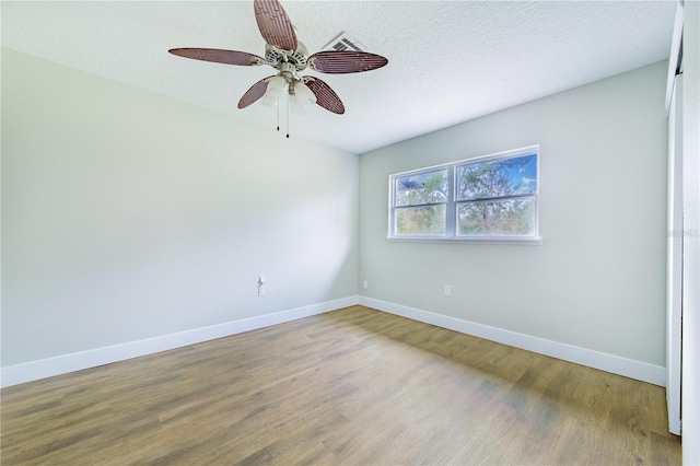 empty room featuring hardwood / wood-style floors, ceiling fan, and a textured ceiling