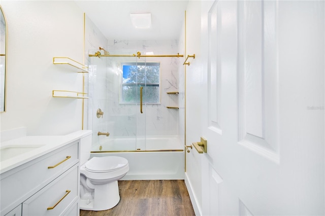 full bathroom featuring shower / bath combination with glass door, vanity, wood-type flooring, and toilet