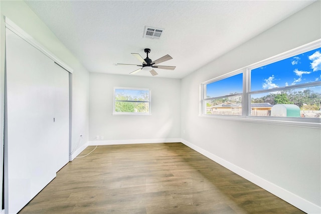 unfurnished bedroom with ceiling fan, wood-type flooring, and a textured ceiling