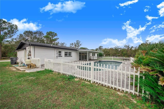 back of house featuring a fenced in pool, a patio area, and a lawn