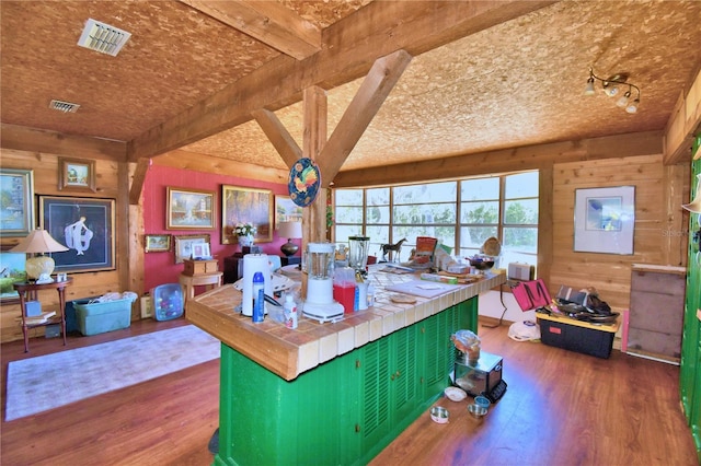 kitchen with tile counters, beamed ceiling, dark hardwood / wood-style floors, and green cabinetry