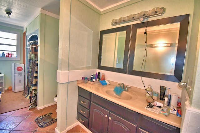 bathroom with toilet, vanity, and ornamental molding