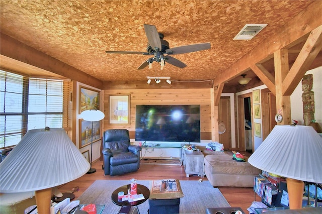 living room featuring wood walls, hardwood / wood-style floors, and ceiling fan