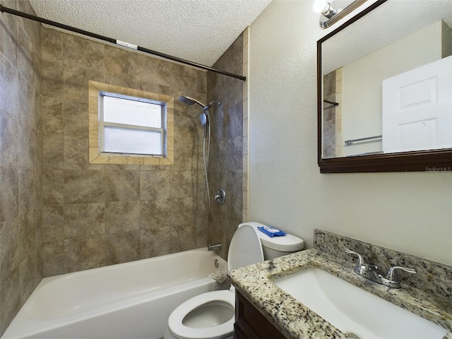 full bathroom featuring vanity, tiled shower / bath combo, a textured ceiling, and toilet