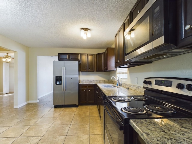 kitchen with light stone countertops, ceiling fan, sink, stainless steel appliances, and light tile patterned floors