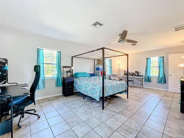 bedroom with multiple windows, ceiling fan, and light tile patterned floors