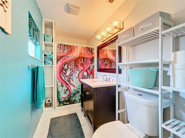 bathroom featuring toilet, vanity, tile patterned floors, and curtained shower