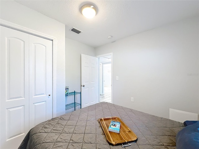 bedroom featuring a textured ceiling and a closet