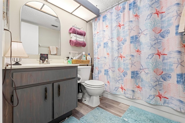 full bathroom with toilet, a textured ceiling, vanity, shower / bathtub combination with curtain, and hardwood / wood-style flooring