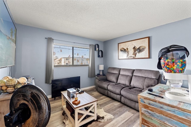 living room with a textured ceiling and light wood-type flooring