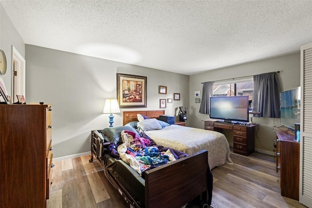 bedroom with a textured ceiling and light wood-type flooring