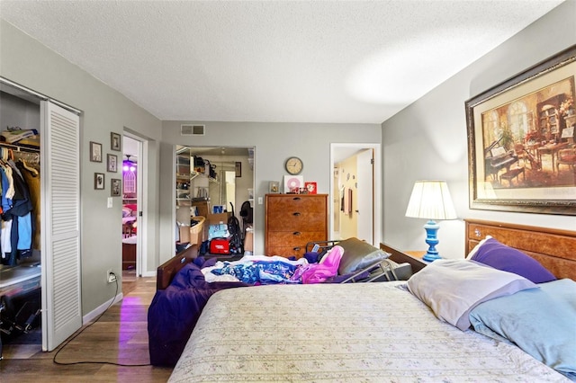 bedroom featuring wood-type flooring, a textured ceiling, and a closet