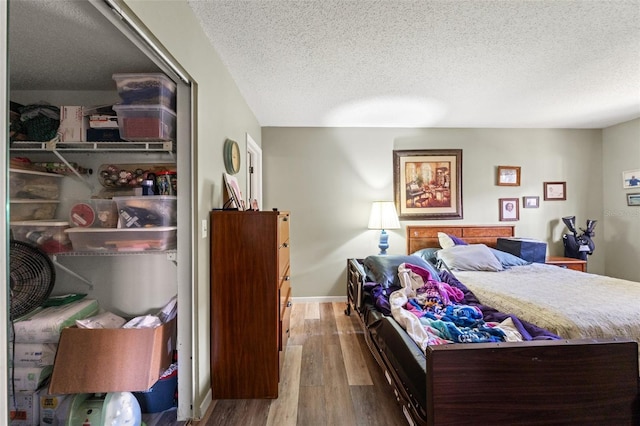 bedroom with hardwood / wood-style flooring and a textured ceiling