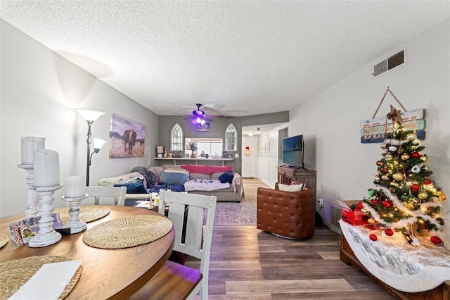 dining room with ceiling fan, wood-type flooring, and a textured ceiling