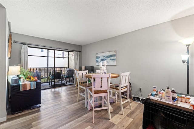 dining space with light hardwood / wood-style floors and a textured ceiling