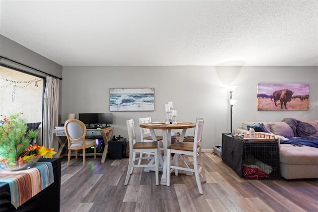 dining space featuring hardwood / wood-style flooring and a textured ceiling