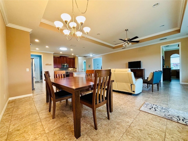 dining area featuring ceiling fan with notable chandelier, a raised ceiling, and crown molding