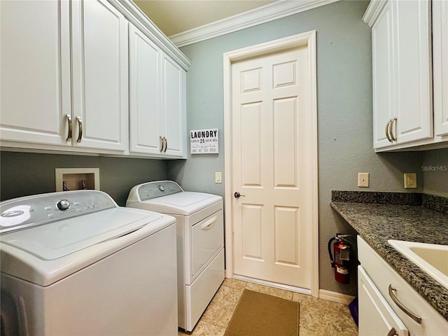 laundry area with washing machine and clothes dryer, sink, cabinets, and ornamental molding