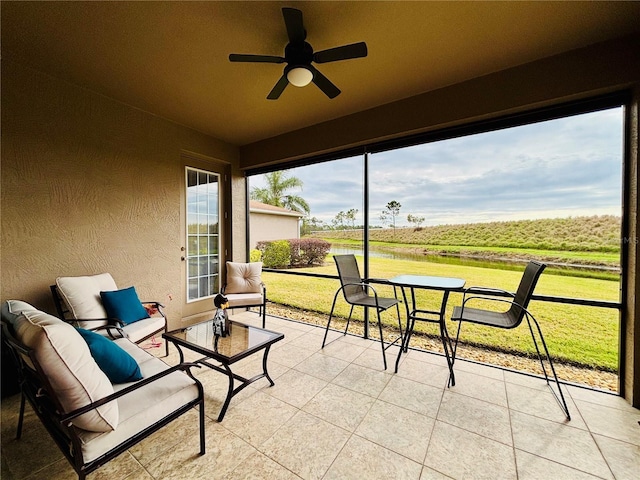 sunroom / solarium with ceiling fan and a rural view