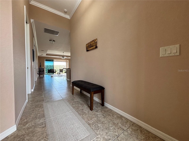 hall featuring light tile patterned floors and ornamental molding