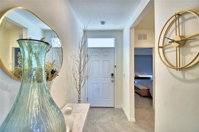 entrance foyer featuring a textured ceiling and light tile patterned flooring