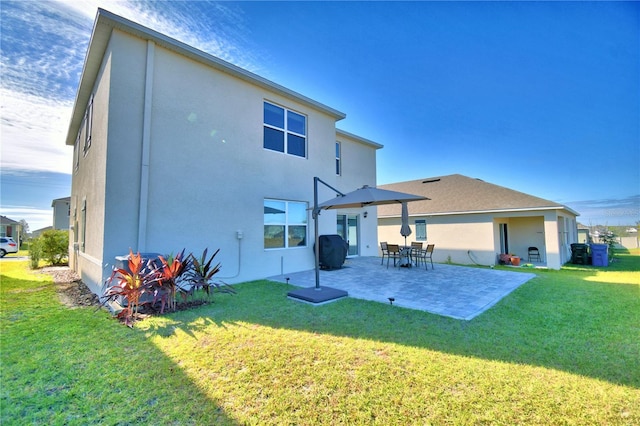 rear view of property with a lawn and a patio area