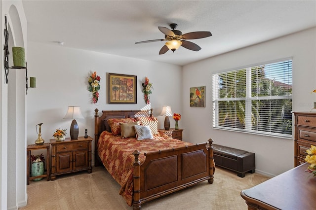 bedroom with baseboards, a ceiling fan, and light colored carpet