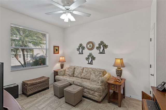 living area with ceiling fan and baseboards