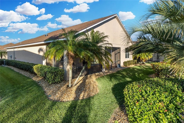 view of side of property with a yard and stucco siding