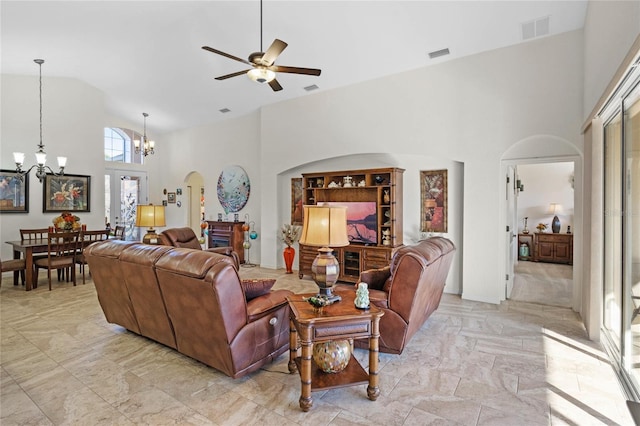 living area featuring arched walkways, high vaulted ceiling, and visible vents