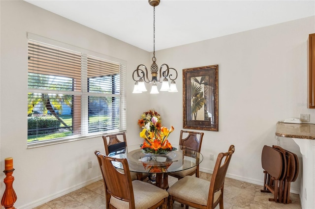 dining space featuring baseboards and a notable chandelier