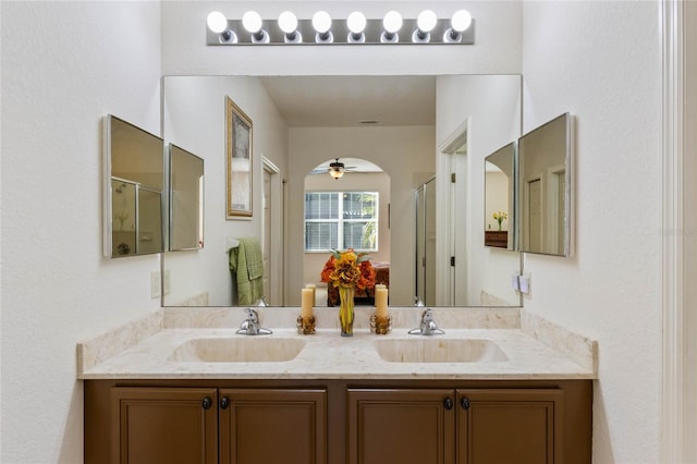 bathroom with double vanity, a stall shower, and a sink