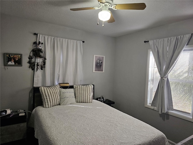 bedroom featuring ceiling fan and a textured ceiling