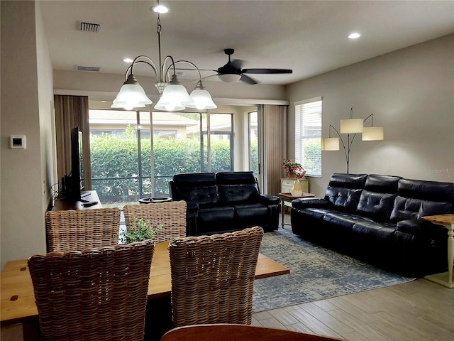 living room featuring hardwood / wood-style floors and ceiling fan with notable chandelier