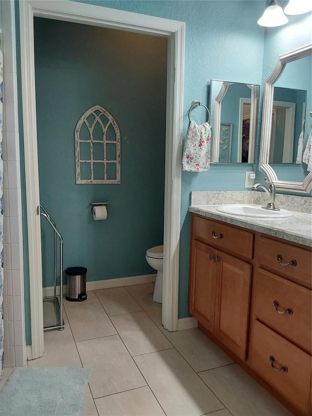 bathroom featuring vanity, curtained shower, tile patterned floors, and toilet