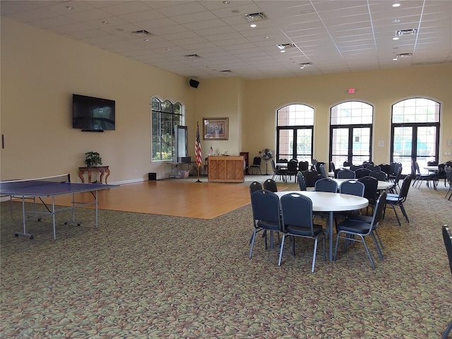 dining room with a towering ceiling and a paneled ceiling