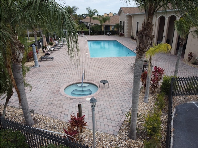 view of pool featuring a community hot tub and a patio area