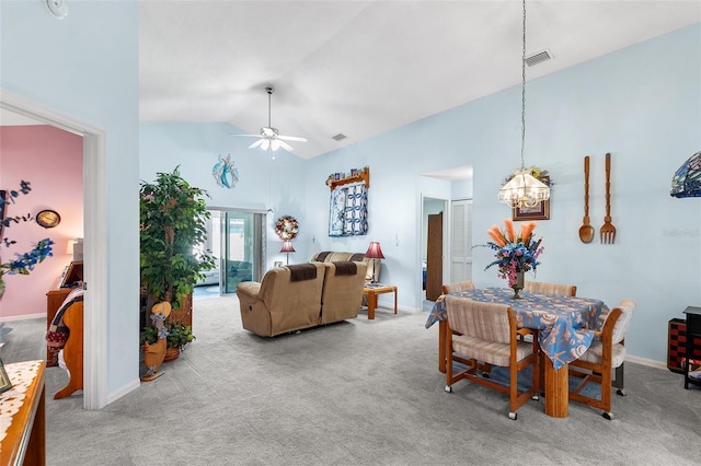 carpeted dining room featuring ceiling fan with notable chandelier and high vaulted ceiling