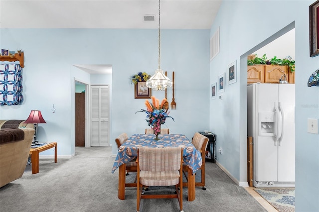 carpeted dining room featuring an inviting chandelier